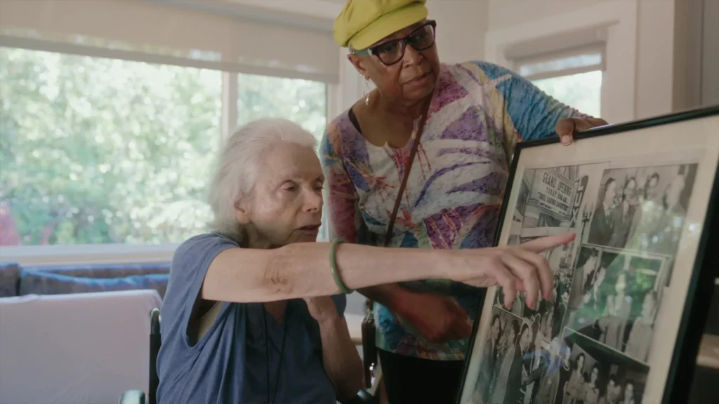 A caregiver and client looking through family photographs at home