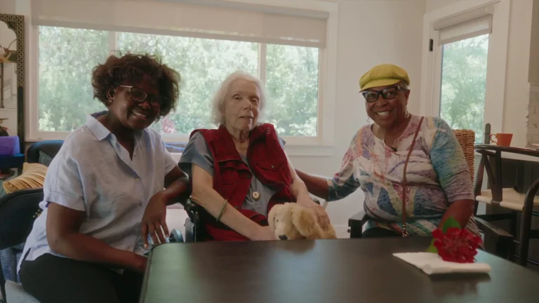Two At Home Caregivers caregivers with a client at her dining table