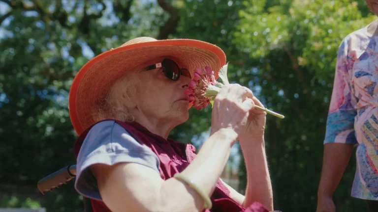 A client enjoying flowers outdoors alongside her caregiver