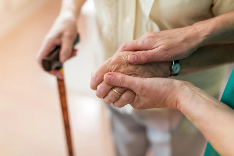 A caregiver holding a client's hand